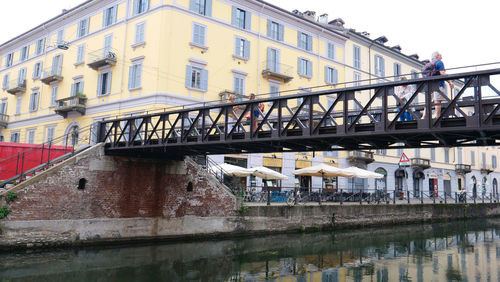 Low angle view of bridge over river against buildings