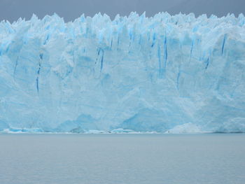 Scenic view of frozen lake against blue sky