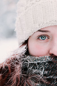 Close-up portrait of woman with blue eye during winter