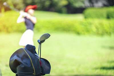 Close-up on golf clubs in bag on course