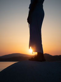 Young woman at white limestone beach sarakiniko on greek island milos at sunrise