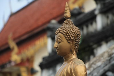 Statue of buddha against building