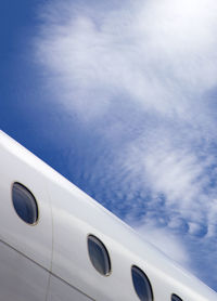 Fuselage of jet airplane against blue cloudy skies