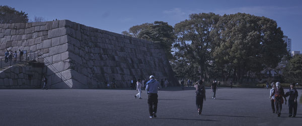 People walking on street in city against sky