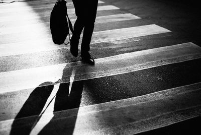Low section of woman walking on zebra crossing