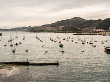 Sailboats in sea against sky