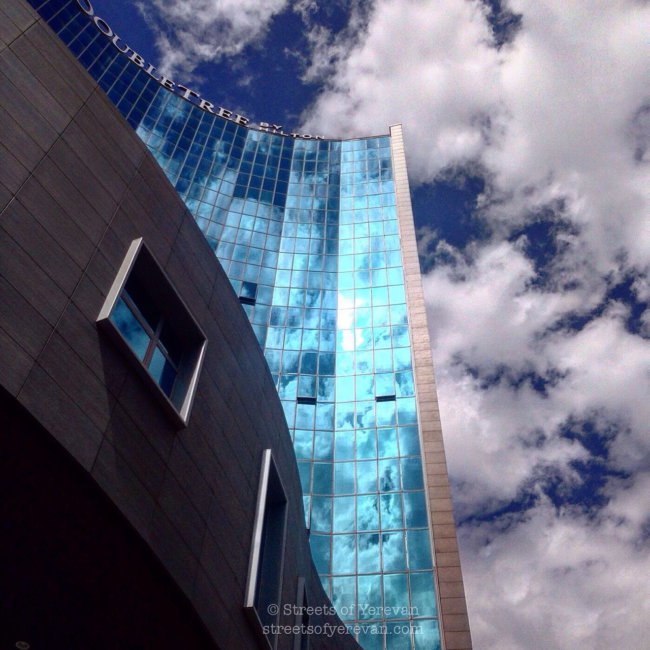 architecture, low angle view, built structure, building exterior, sky, modern, cloud - sky, office building, city, tall - high, skyscraper, building, cloudy, tower, cloud, glass - material, reflection, day, outdoors, no people