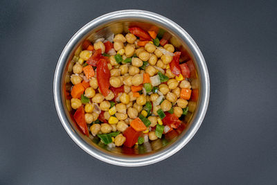 High angle view of chopped fruits in bowl against black background