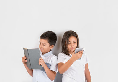 Happy friends holding camera over white background