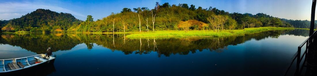 Scenic view of lake by trees against sky