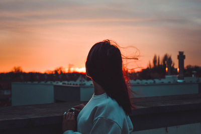 Rear view of woman looking at sunset