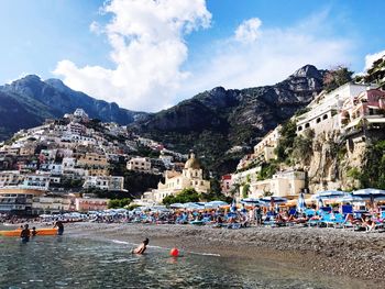 Scenic view of beach by buildings against sky