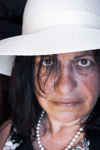 Close-up portrait of mature woman wearing hat
