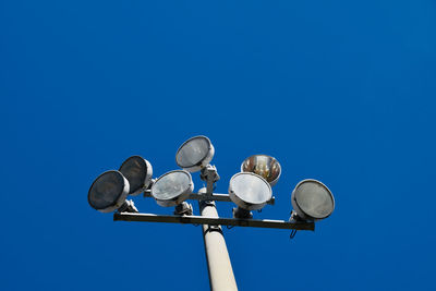 Low angle view of stadium light against clear blue sky