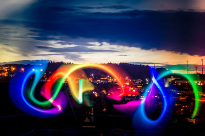 Illuminated light trails against sky at night