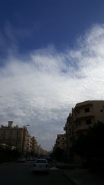 Cars on road in city against sky