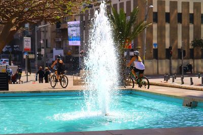 People by swimming pool in city