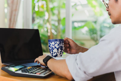 Midsection of woman using laptop