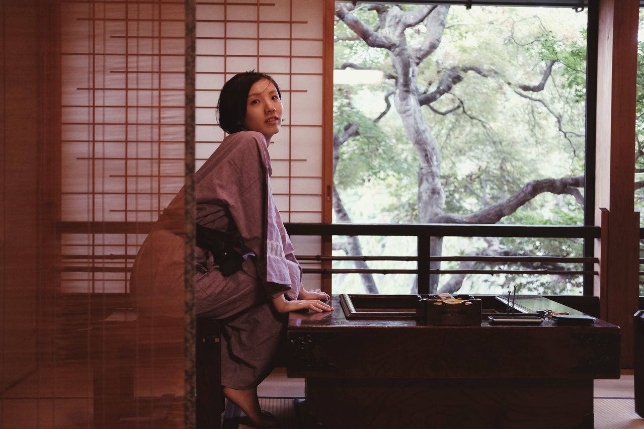 WOMAN STANDING ON TABLE AT HOME