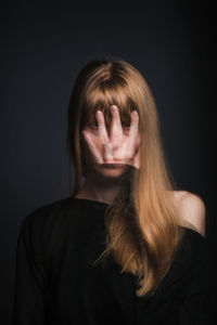 Portrait of a beautiful young woman over black background