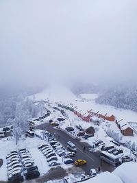 High angle view of snow covered cars against sky