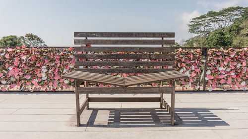 Empty bench in park against sky