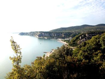 Scenic view of sea and mountains against sky