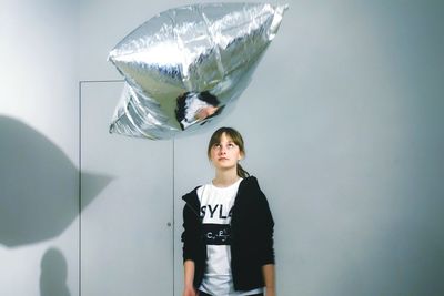 Portrait of boy standing against wall