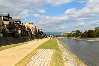 Kyoto kamo river amidst houses against sky in city