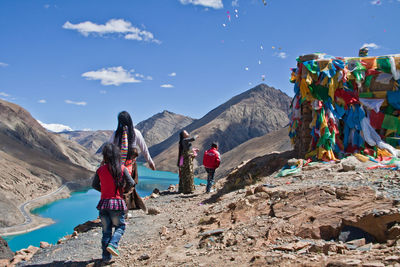 People on mountain against sky