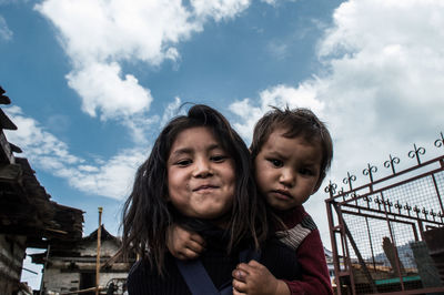 Portrait of happy mother and daughter against sky