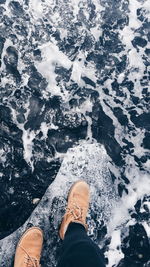 Low section of man standing in water