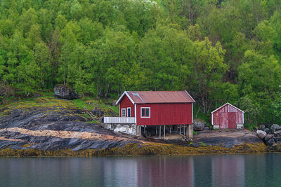 Built structure by lake against trees