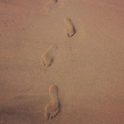 High angle view of footprints on sand at beach