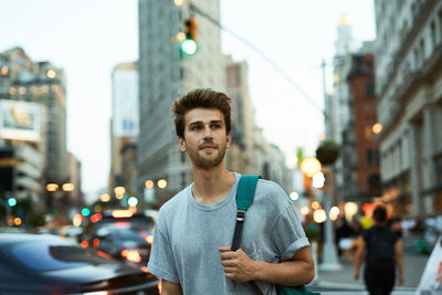 Portrait of man using smart phone on city street