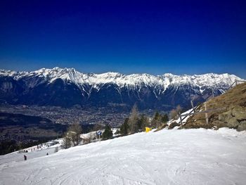 Scenic view of snowcapped mountains against blue sky