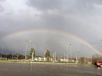 Rainbow over city against sky