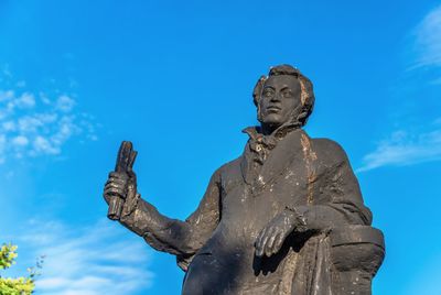 Low angle view of statue against blue sky