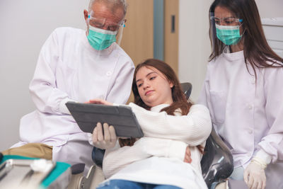 Rear view of doctor examining patient at clinic