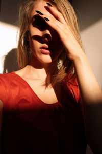 Close-up of beautiful woman covering face with hand