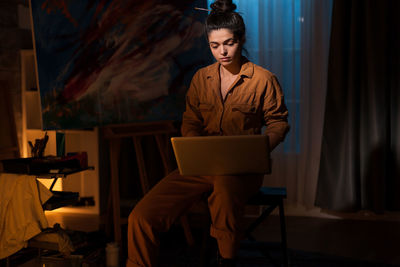 Woman using laptop while sitting on chair