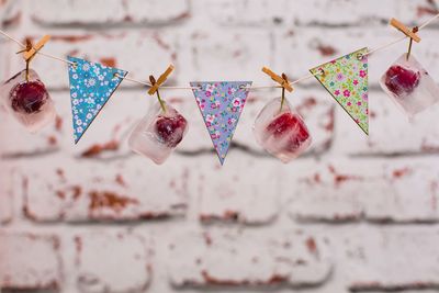 Frozen fruits hanging on bunting against wall