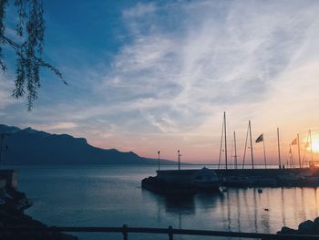 Silhouette of sailboats in sea against cloudy sky