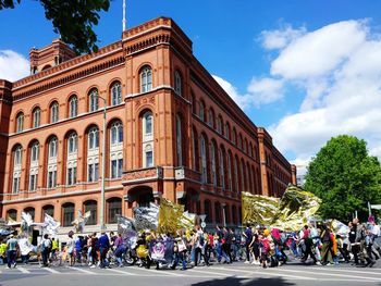 People in front of building against sky