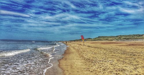 Scenic view of beach against cloudy sky