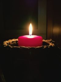 Lit candle in dark room