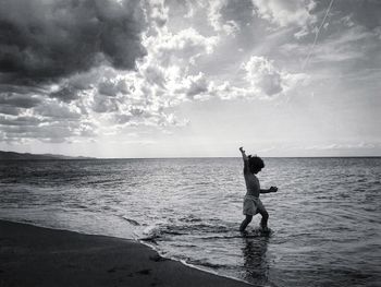 Man standing at beach against sky