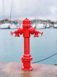 Close-up of red ship moored at harbor against sky