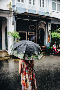 Rear view of woman holding umbrella