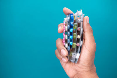 Close-up of hand holding blue background